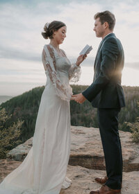 Bride and Groom exchaning vows on Payson Rim with sun behind them