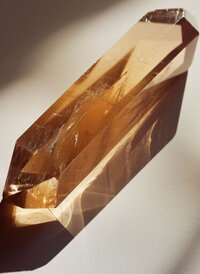 Golden crystal reflecting sunlight, representing focused energy and clarity for healing intentions