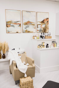 hair washing station in a hair salon with a leather chair and landscape pictures on the walls