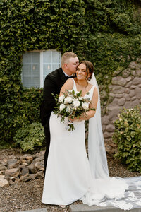 groom kisse bride's cheek