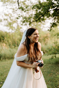 A photo of Kelsie holding her film camera