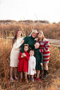 Family enjoying a photo session in a grassy field in Utah, captured by Lamblight Photography