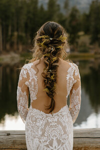 photo of bride wearing her wedding gown looking out over a lake taken by Adventure elopement photographer in breckenridge