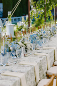 Photo of wedding reception table decorated with blue flowers and dishes taken by Wedding photographer Portland Maine