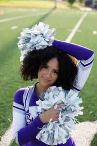 Outdoor senior photo of cheerleader girl with pom poms senior portrait photographer