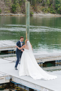 Photo of bride and groom holding hands and smiling at each other taken by Documentary wedding photographer Portland Maine