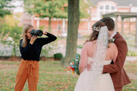 Nikki takes a picture of a newlywed couple.