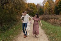 Family of four walking amongst fall leaves during Cleveland mini session