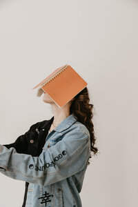 A fun photo of a UGC coach with her journal on her face, showing her fun personality. 