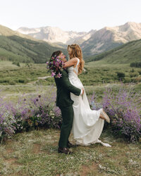 bride and groom embracing with mountains in the background