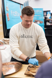 Founder Todd Kopet offering sourdough samples at the Alkeme booth during a gluten-free industry event.