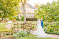 The bride smiles at the camera in front of Alexander Homestead in Charlotte.