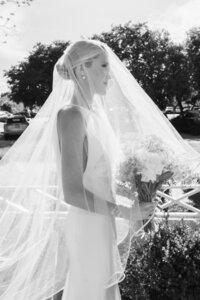 Black and white portrait of bride with veil over her face