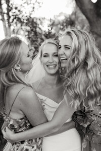 bride hugging her sisters