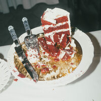 A partially eaten wedding cake on a table, capturing the joyful aftermath of a wedding celebration.