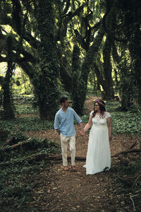 Couple holding hands walking through the rainforest