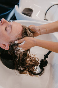 Salon Beau stylists creating a custom low-maintenance hairstyle with lived-in color for a client.