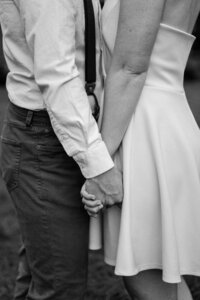 black and white image bride and groom  holding hands