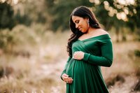 Pregnant mom in green gown at a field near Orlando FL