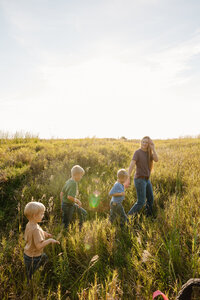 Kids following their parent through a field