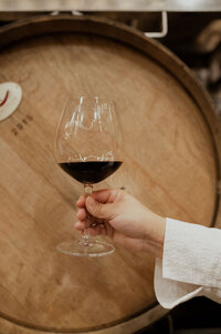 glass of wine by wine barrel
