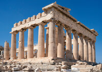 The image shows the Parthenon, an ancient Greek temple on the Acropolis of Athens. It features Doric columns and a partially restored structure, set against a clear blue sky. Scattered ruins are visible around the base.