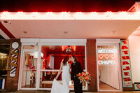 A couple kisses in front of Sure Thing chapel in Las Vegas