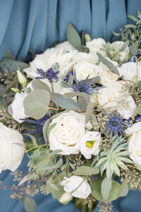 blue and white  bouquet on a dusty blue background during a hickory nc wedding