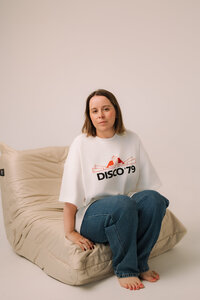 Liv Rollings sitting on cream chair in studio