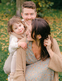 A family cuddles and laughs during their fall photoshoot in Vondelpark. 