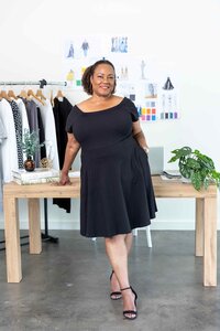 Brand photography for an entrepreneur in a sleek black dress, photographed in her professional office environment