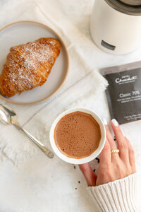 a flat lay of hot chocolate and a croissant