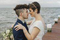 A newlywed couple standing forehead to forehead with their eyes closed