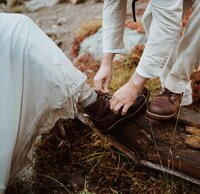 bride helping put on groom's boots