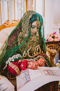 Muslim bride signing the papers during her nikkah ceremony at mansion at mountain lakes in nj