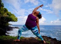 A Soma Yoga Institute student in a reverse warrior yoga pose on a beach in Hawaii.