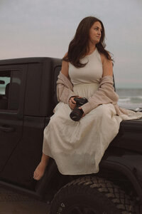 commercial photographer sitting on jeep on beach in emerald isle nc