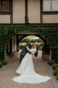 Bride and Groom enjoy a romantic kiss framed by the ivy arch at St. Clement's Castle in Portland, CT