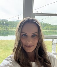 Life coaching client standing in front of a window, smiling