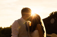 Husband and wife kissing at sunset
