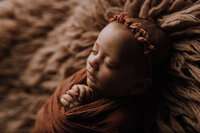 Studio portrait of a cute newborn in green wrap
