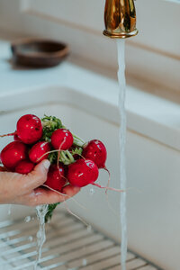 Sam washing squash in her kitchen sink