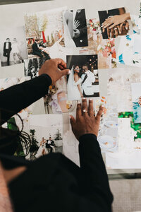 Photo from above of Juma Waganda's hands arranging printed photos on a tabletop