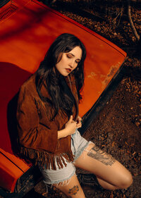 Commercial traveling photographer from Columbia, South Carolina posing on top of a vintage orange truck.