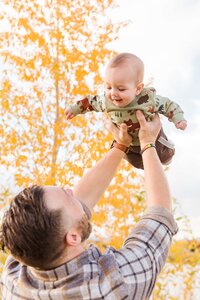 dad holds son up in the air denver colorado