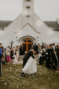 Newlyweds celebrate with a petal toss outside the chapel after their Long Beach wedding, coordinated by Beyond the Event and photographed by Kellie Jane Photography.