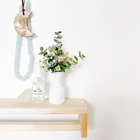 Chamomile Flower, Eucalyptus, Tweedia in Vintage Milk Vase, beside Kismet Lavender Spray, Styled with Clear Quartz, Seaglass Beads, Hanging Moon Charm  on Ikea Wood Shelf