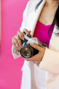 Entrepreneur resources and tools displayed by Dallas brand photographer Sophie K. Hunter, featuring a professional camera and a vibrant pink background in her studio photoshoot.