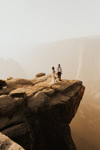 elopement couple on the edge of a cliff at yosemite national park