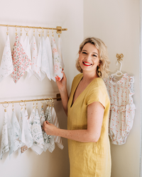 Jess Meyer arranging fabric swatches of her watercolour pattern designs on a hanging rail in the studio